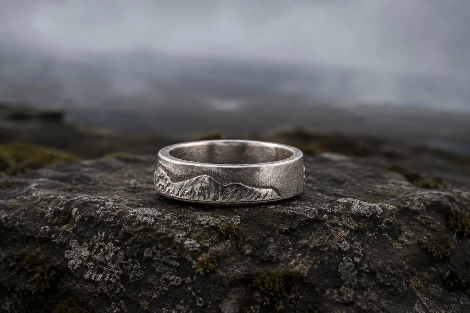 National Three Peaks sterling silver ring resting on dark upland stone.