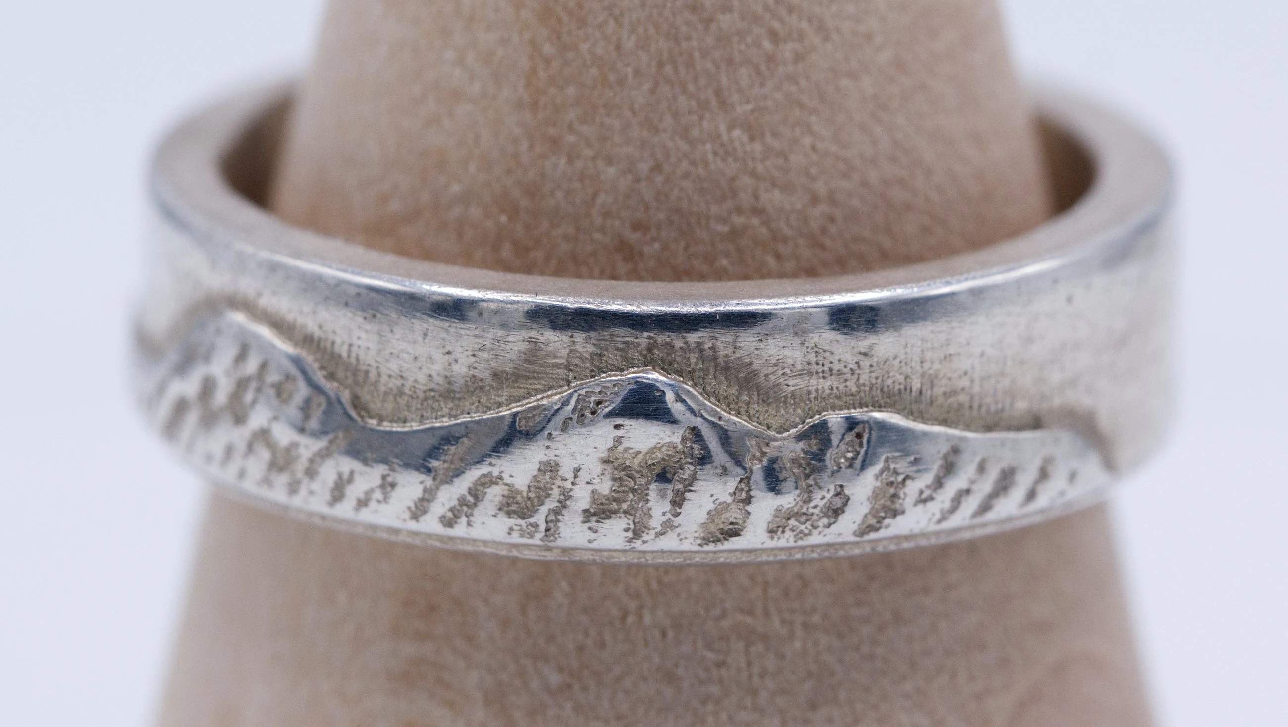 The ridgeline filling the frame on a ring cone, showing the cast peaks and the bright edge above them.