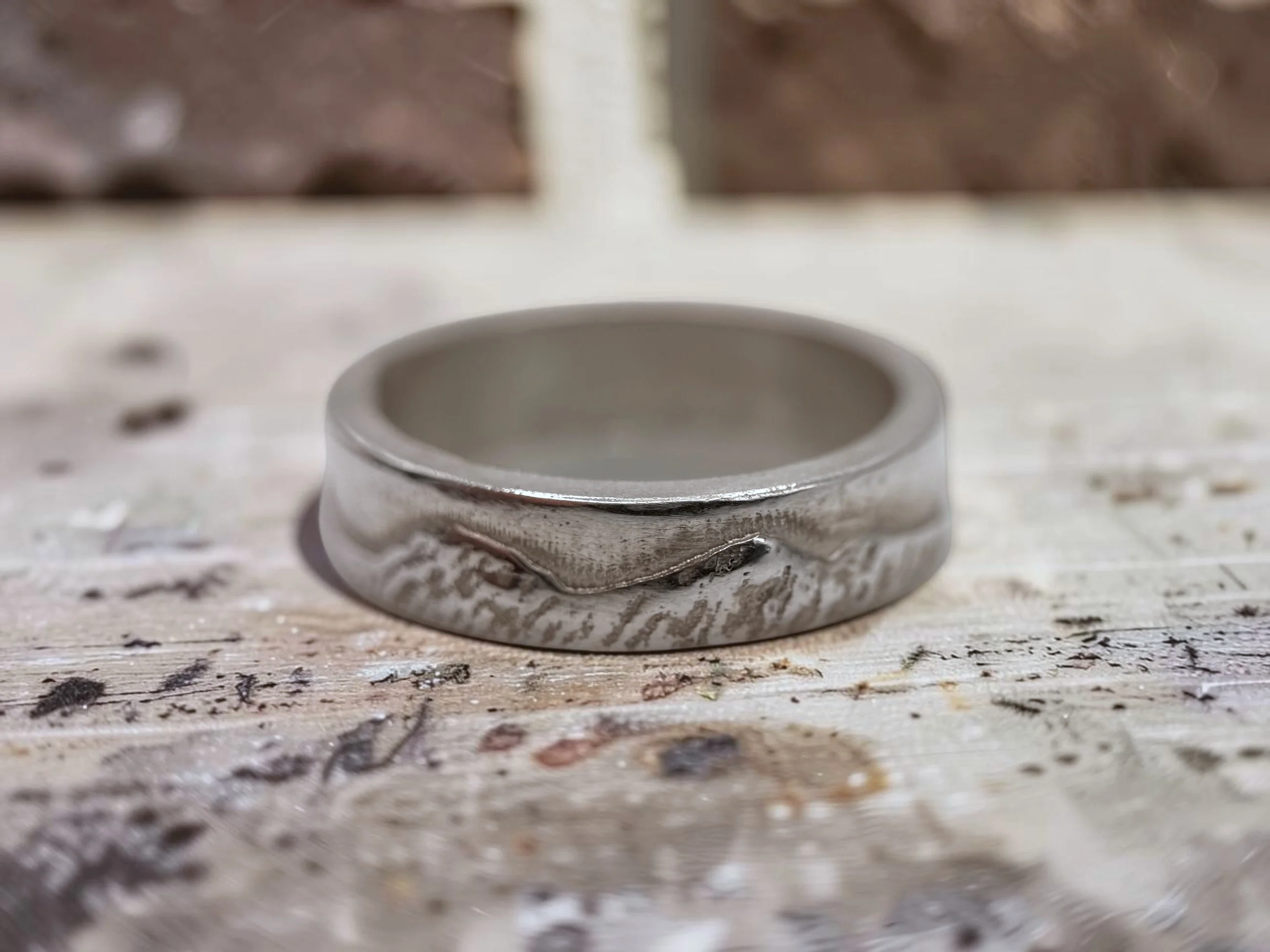The ring photographed on a paint-marked workshop surface.