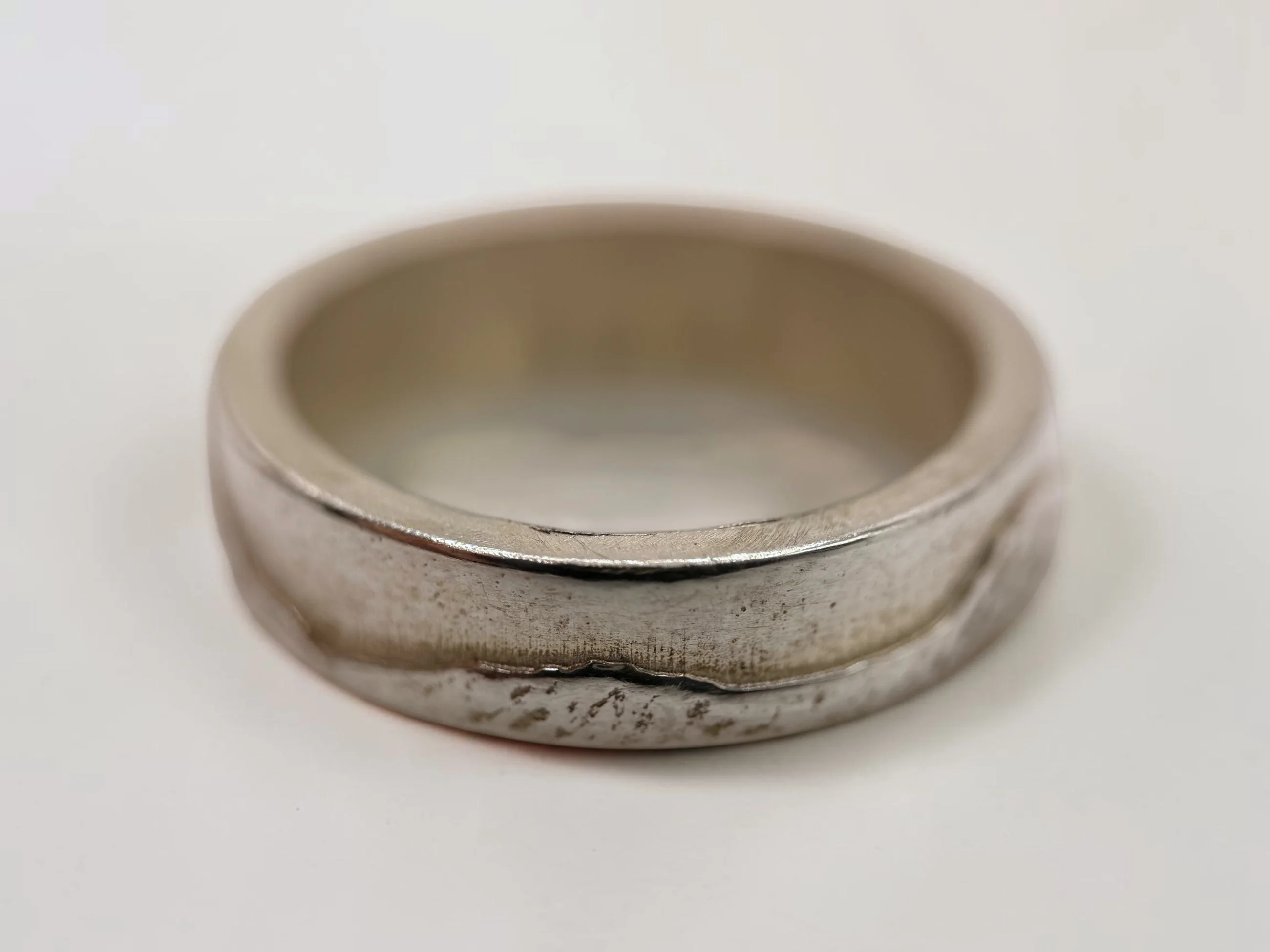 The ring on a pale surface, showing the squared outer edge and the depth of the band.