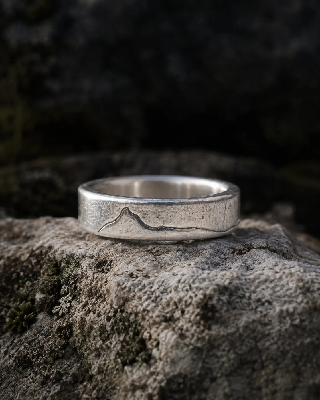 Yorkshire Three Peaks sterling silver ring on dark lichen-covered rock.