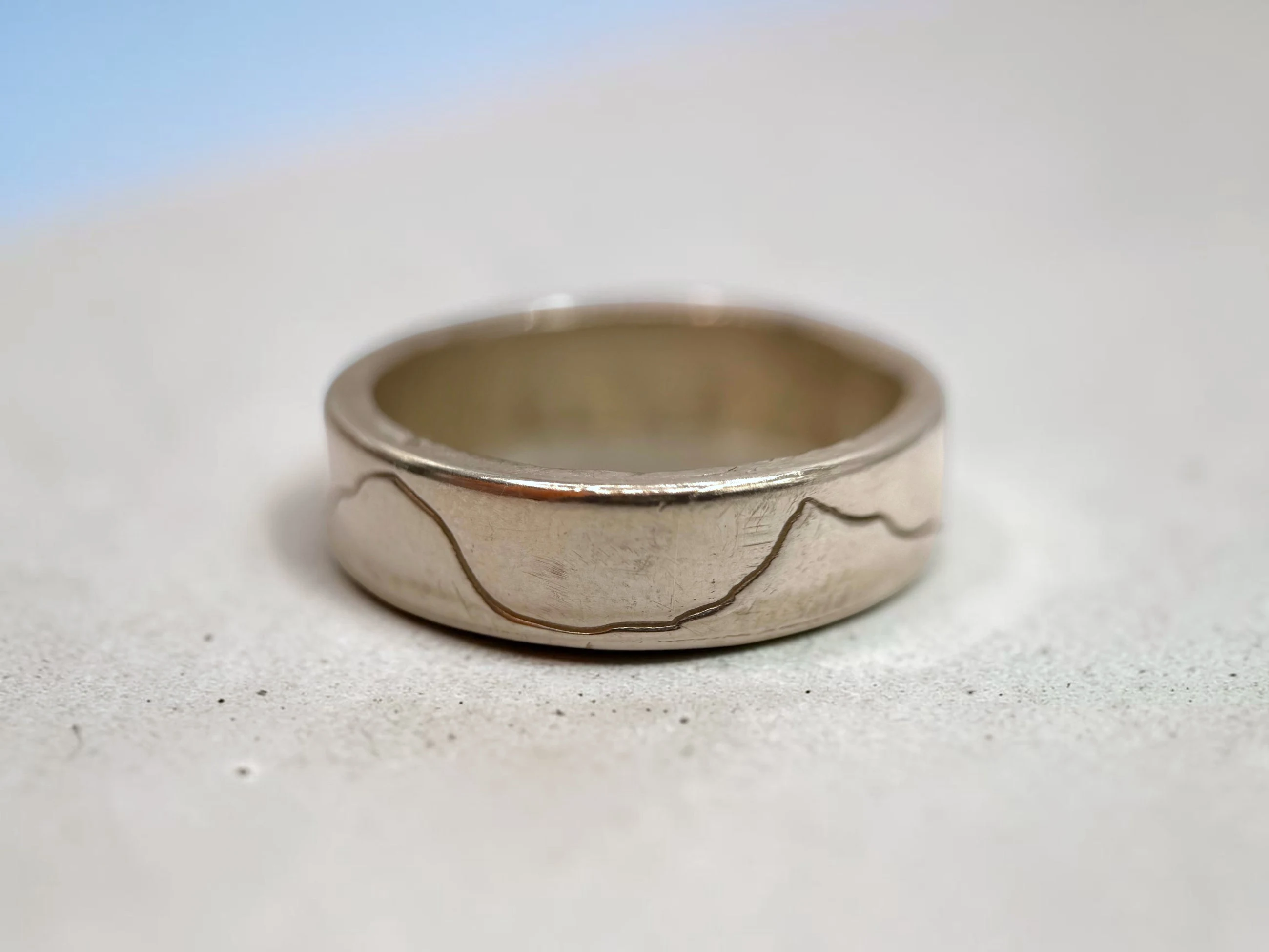 The band turned again, the engraved line dipping and rising as it carries round the ring.